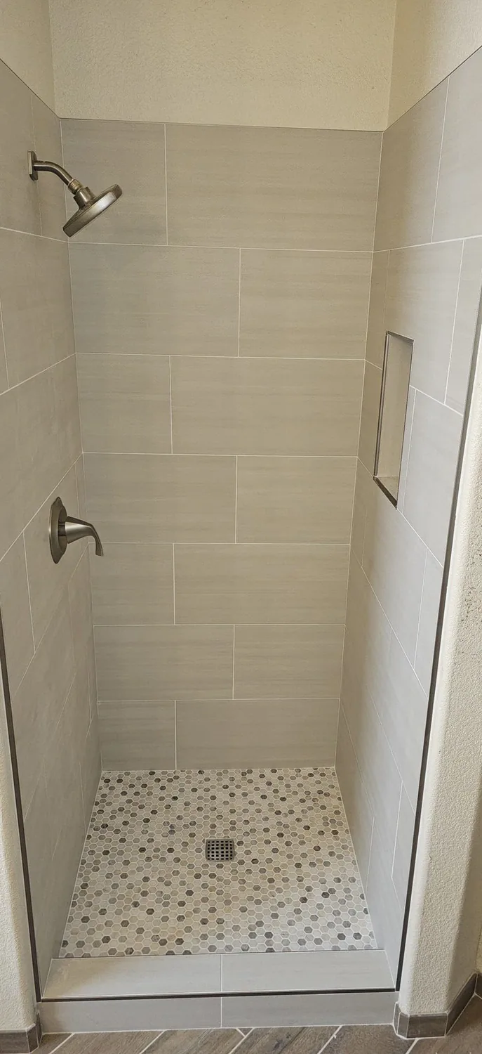 Neutral large-format tiled shower wall and niche
