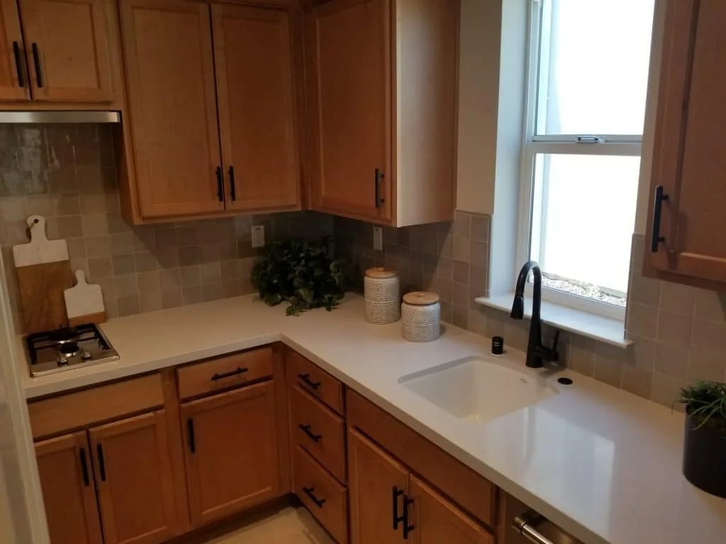 Warm stone-look tile backsplash under wood cabinets
